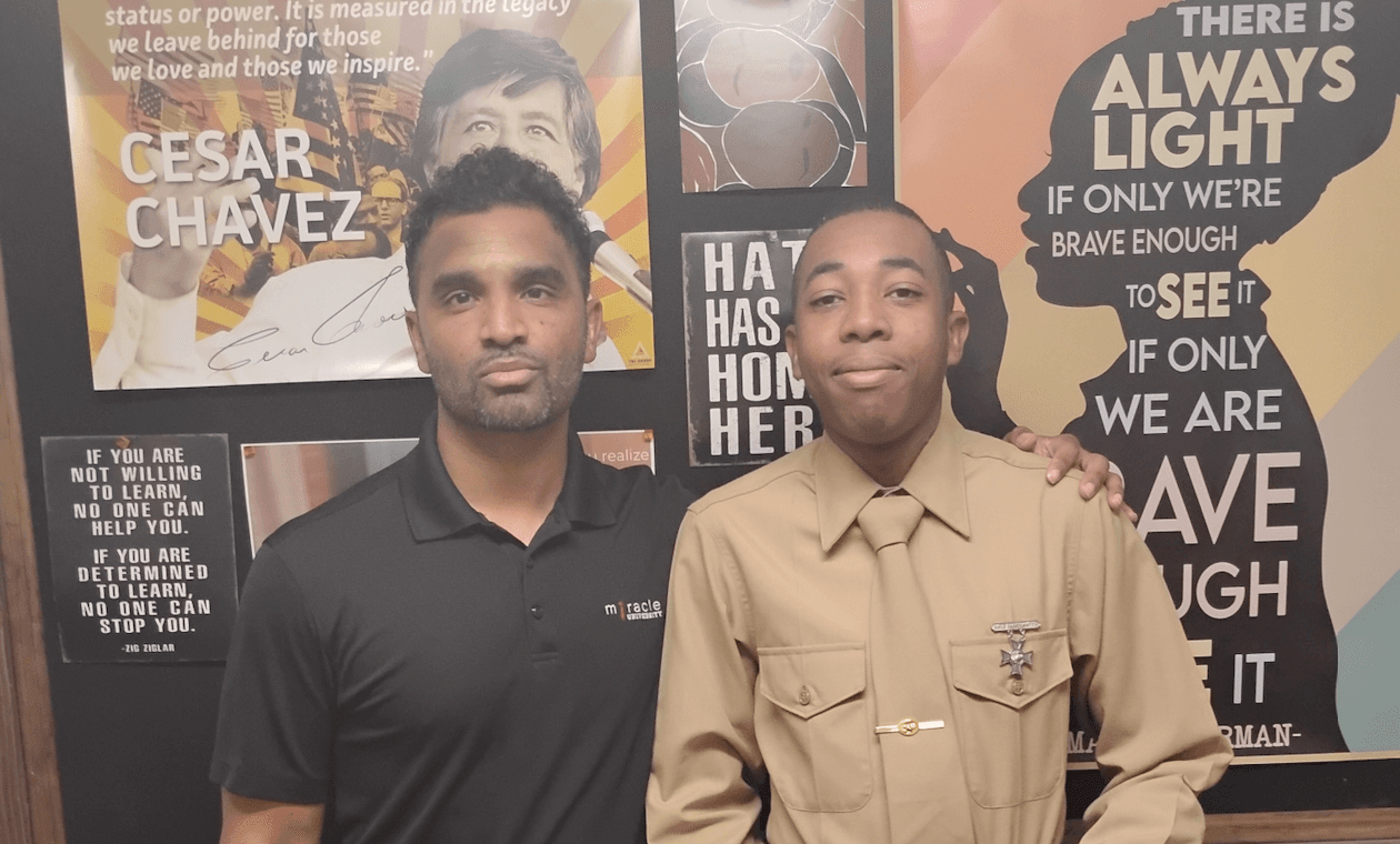 Man standing next to young military member