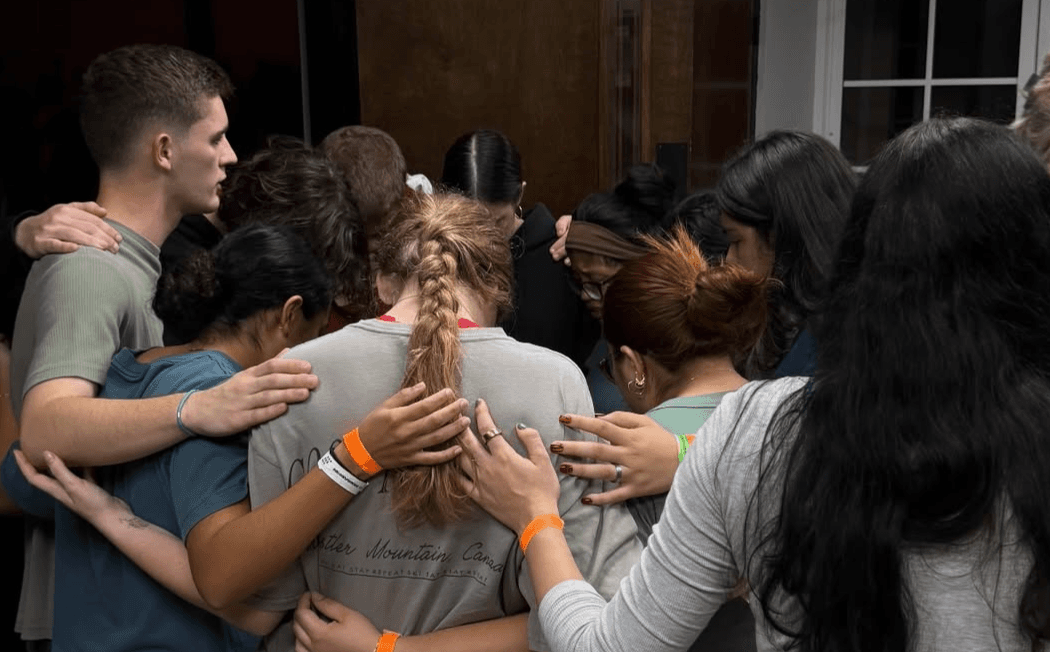 Students in a circle, praying