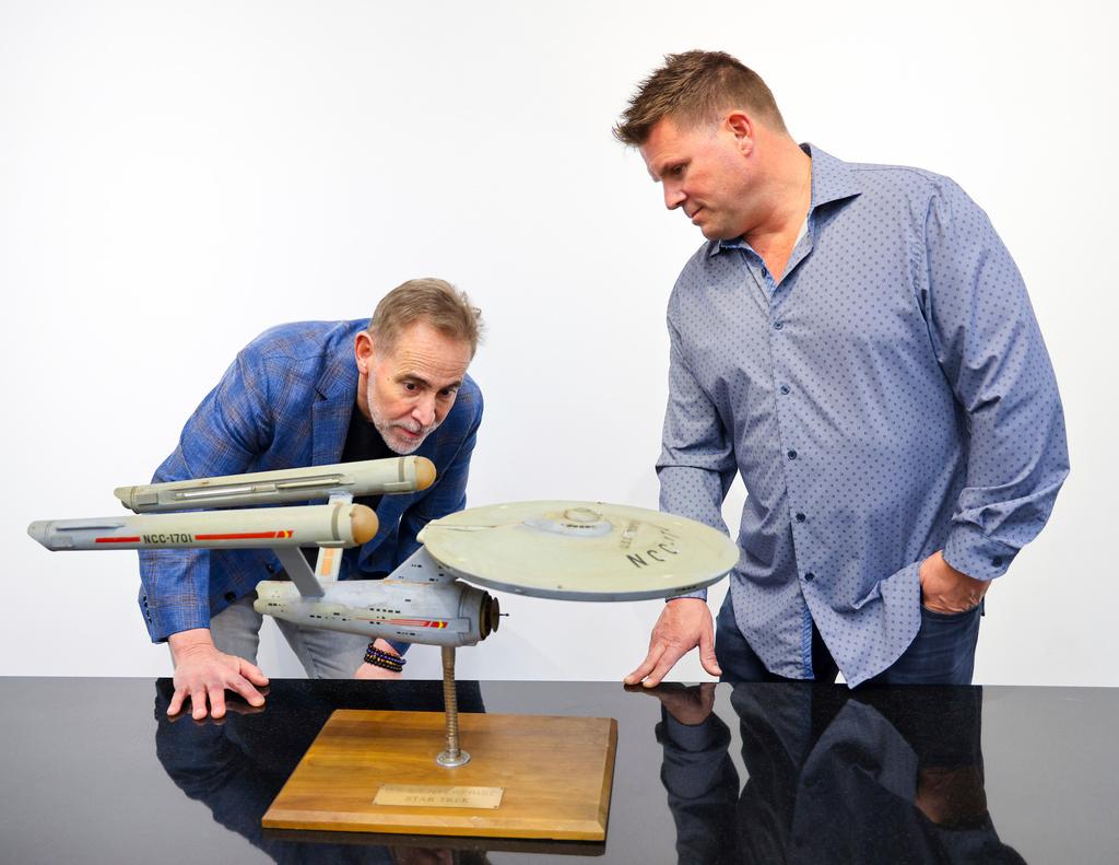 Joe Maddalena, executive vice president of Heritage Auctions, left, and Eugene “Rod” Roddenberry, the son of “Star Trek” creator Gene Roddenberry, view the recently recovered first model of the USS Enterprise at Heritage Auctions in Los Angeles