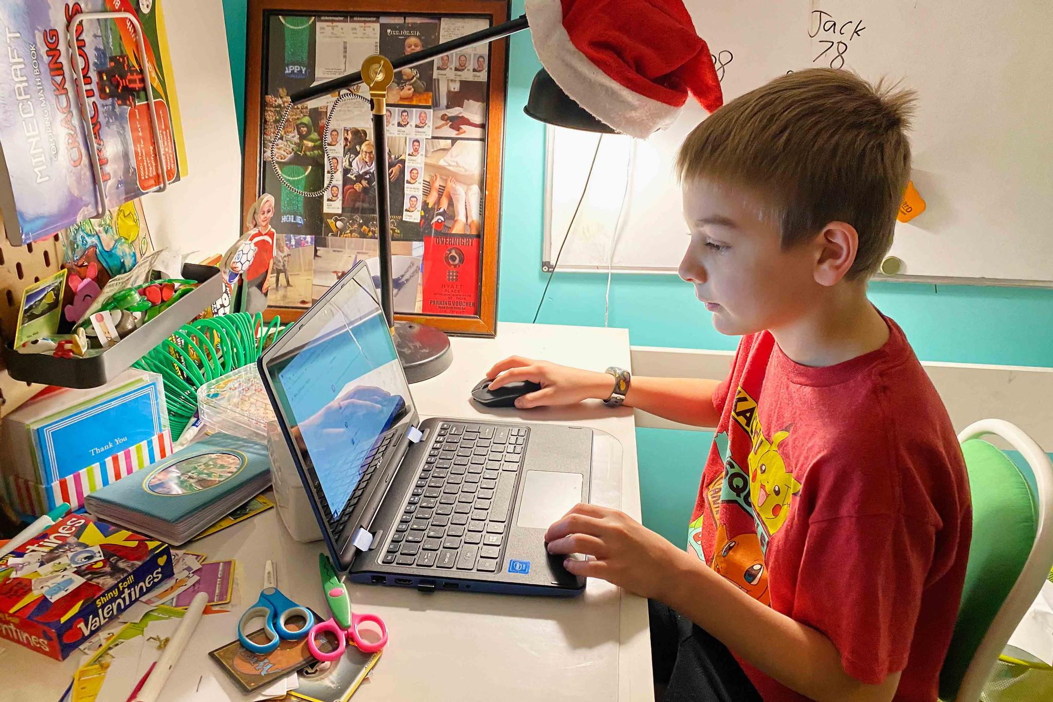 This April 9, 2020, photo released by Kara Illig shows her son, Eli Illig, 10, on his computer in Ebensburg, Pennsylvania