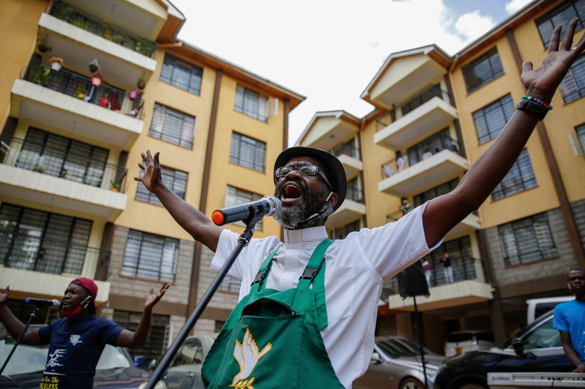 Rev. Paul Machira preaches and sings to residents in an apartment block in Nairobi, Kenya