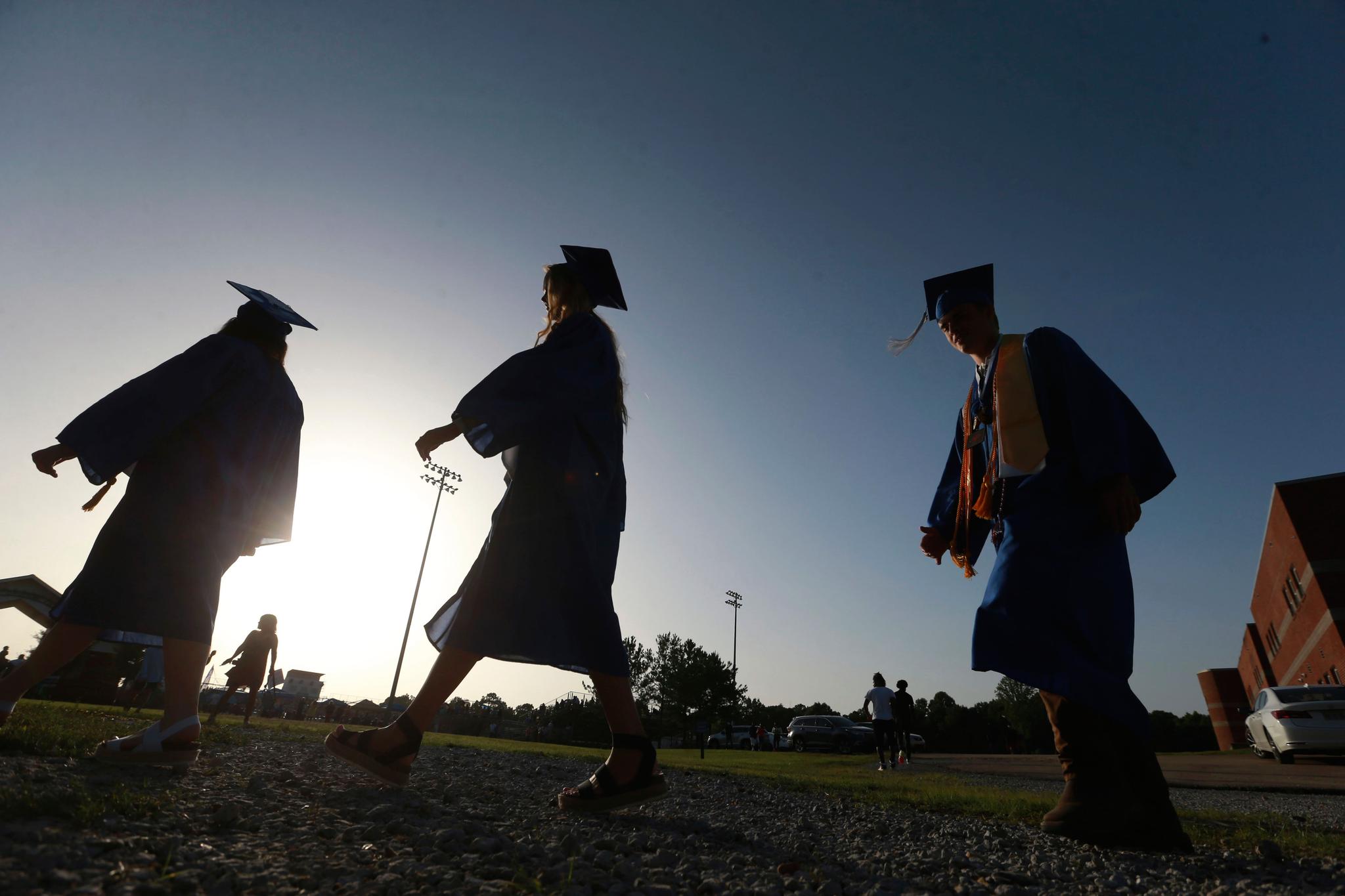 graduating seniors make their way to the football field