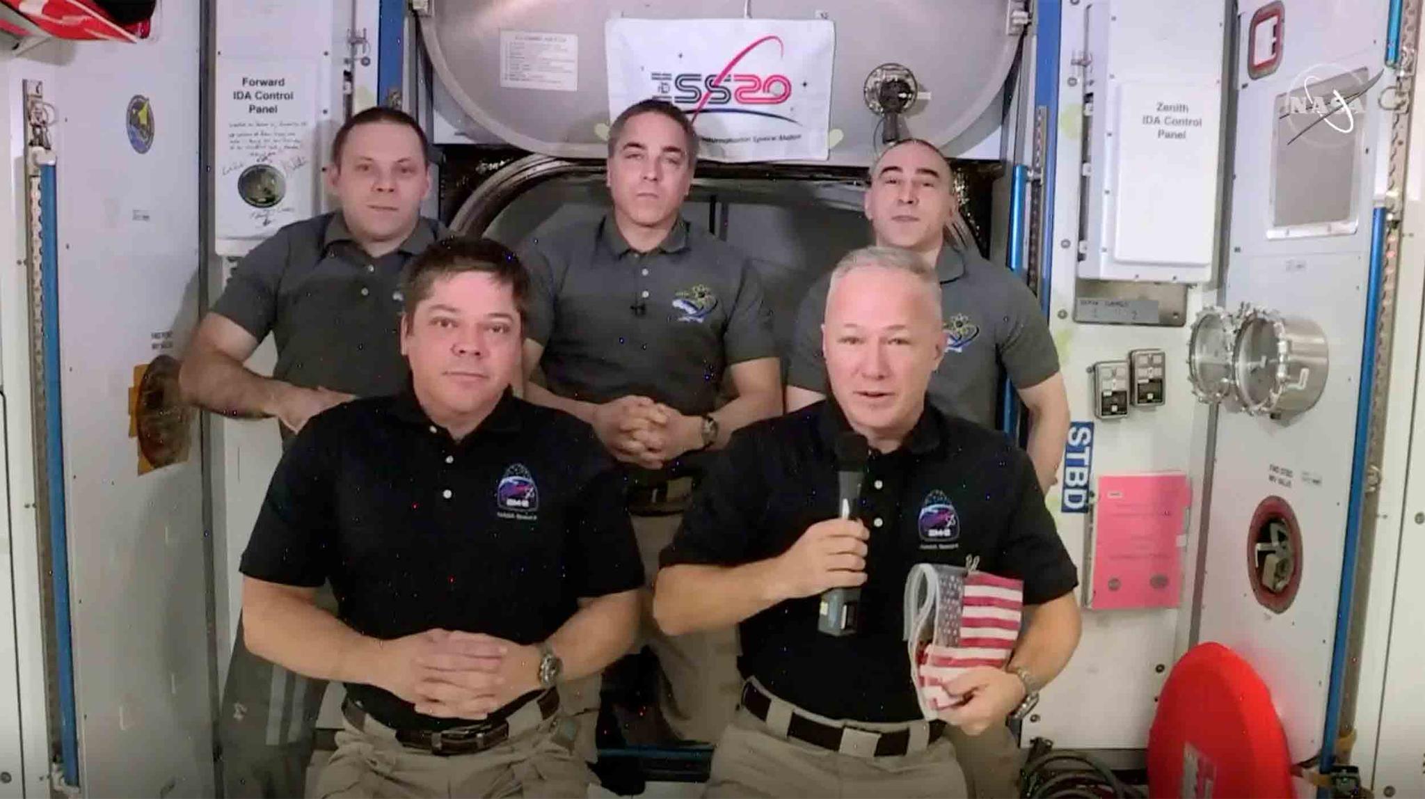 This photo provided by NASA shows, from left, front, astronauts Bob Behnken and Doug Hurley during an interview on the International Space Station on Saturday, Aug. 1, 2020.