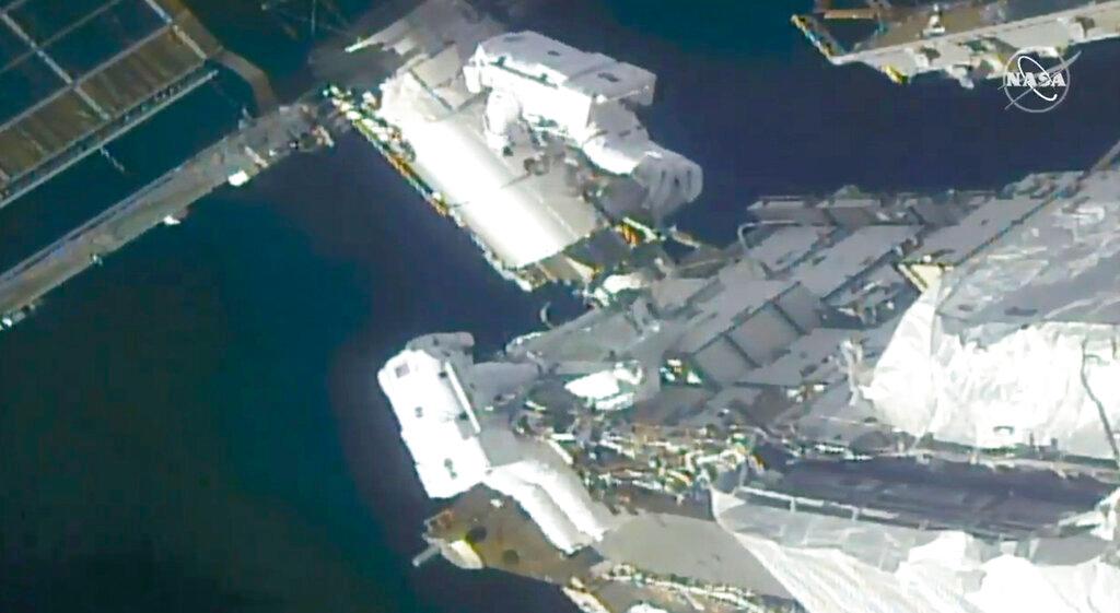 In this image taken from NASA video, NASA astronauts Kate Rubins, top, and Victor Glover work outside the International Space Station Sunday, Feb. 28, 2021. Thespacewalking astronauts ventured out Sunday to install support frames for new, high-efficiency solar panels arriving at the International Space Station later this year.