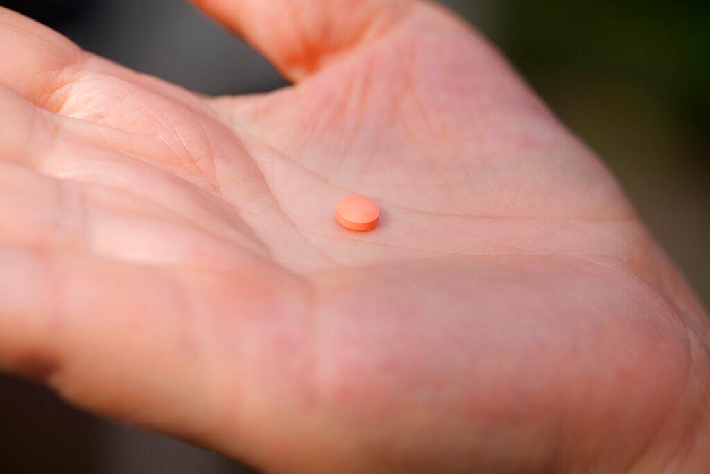 holding an Aspirin pill