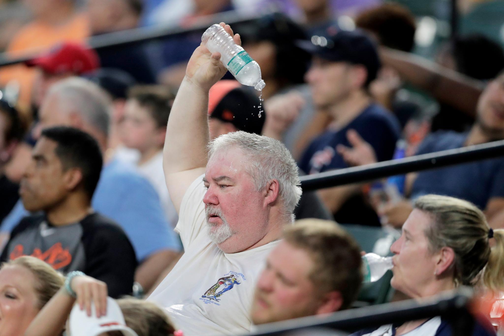 Man Pouring Water Over Head At Baseball Game