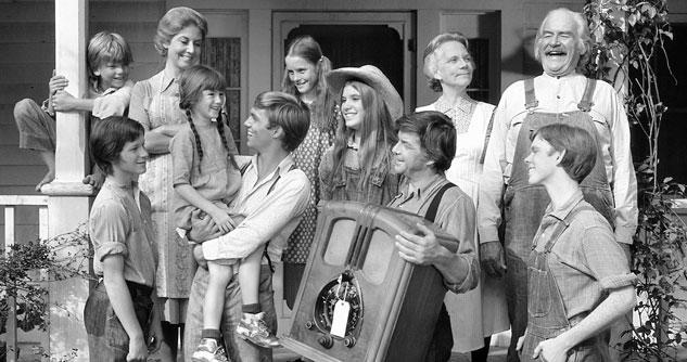 A picture in black and white of a big family on the porch