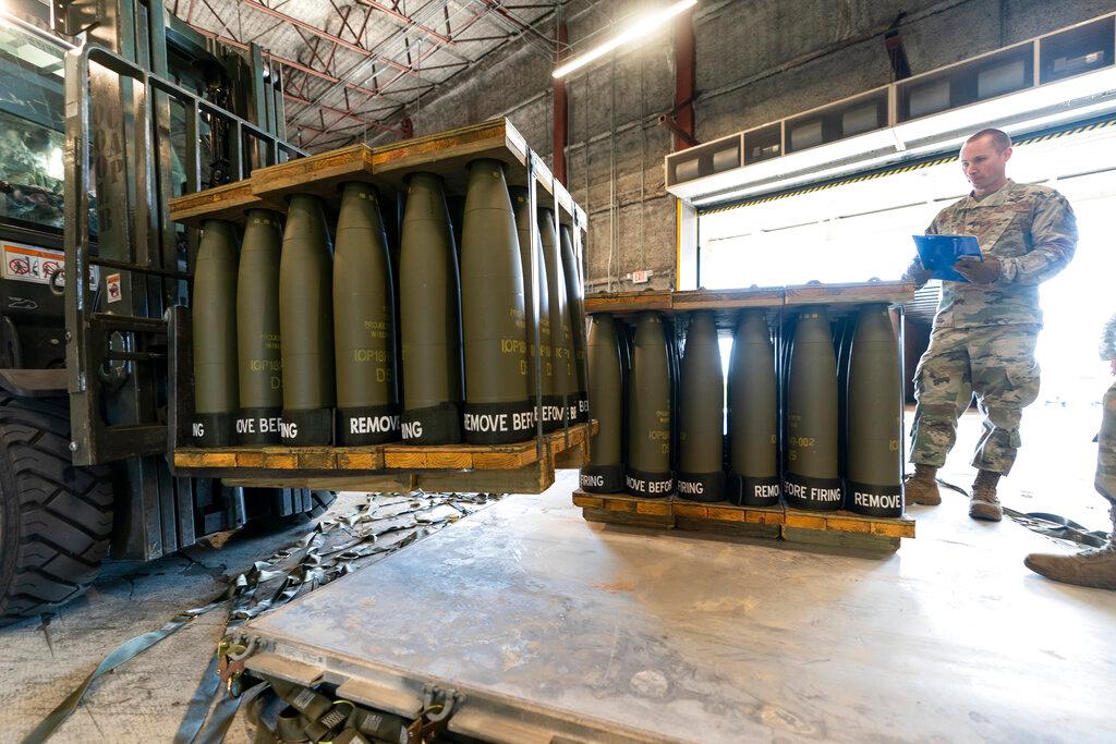  U.S. Air Force Staff Sgt. Cody Brown, right, with the 436th Aerial Port Squadron, checks pallets of 155 mm shells ultimately bound for Ukraine,