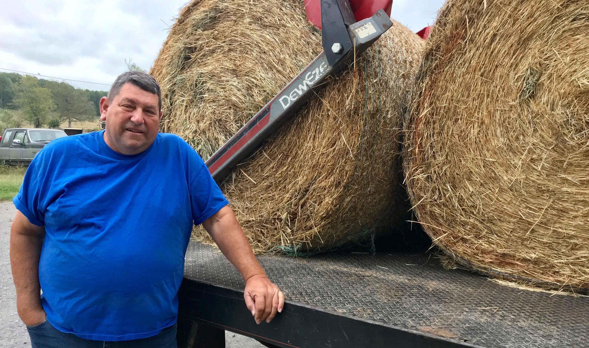 Farmer with hay rolls on truck